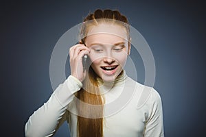 Cute little girl speaking on the cell phone. isolated on gray