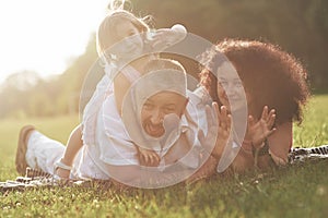 A cute little girl is spending time with her beloved grandfather and grandmather in the park. They had a picnic on the