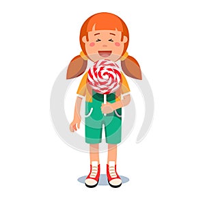 Cute little girl standing with big swirly lollipop