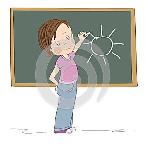 Cute little girl standing in front of the blackboard, drawing sun with chalk, smiling happily