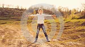 Cute little girl standing with hands to sides on a road