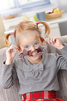 Cute little girl with star shaped glasses smiling