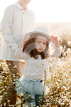 Cute little girl in a straw hat with curly hair