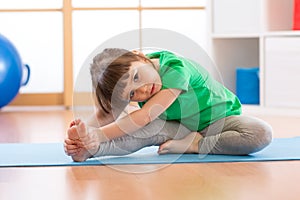 Cute little girl stretching in gym