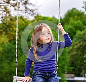 Cute little girl swinging on seesaw