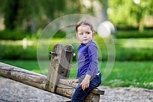Cute little girl swinging on seesaw