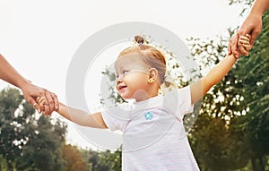 Cute little girl take hands with her relatives people. Walking with kids concept image