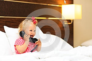 Cute little girl taking on the phone in hotel room