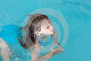 cute little girl taking a swimming lesson in a swimming pool little girl learning to swim in a swimming club