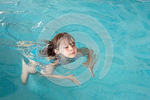 cute little girl taking a swimming lesson in a swimming pool little girl learning to swim in a swimming club