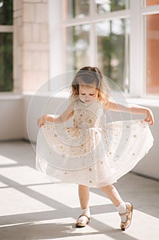 Cute little girl three year old in dress posing for photograper in studio. Beutiful little girl dance photo