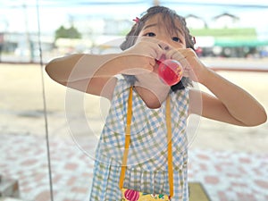 Cute little girl tries to inflate a balloon