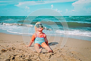 Cute little girl try on sunglasses on beach