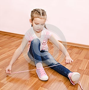 Cute little girl tying her shoes