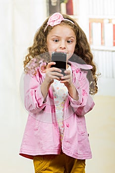 Cute little girl using cell phone