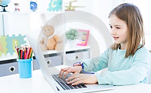 Cute little girl using computer