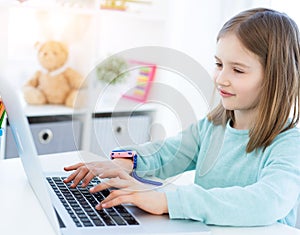 Cute little girl using computer
