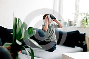 Cute little girl using VR glasses to play a game