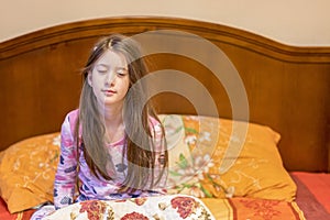 Cute little girl waking up in her bed. child sleepy yawning in bed. Sleepy little
