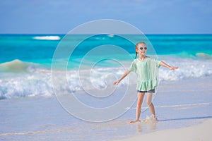 Cute little girl walking at beach during caribbean vacation