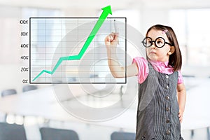 Cute little girl wearing business dress and writing over achievement graph. Office background.