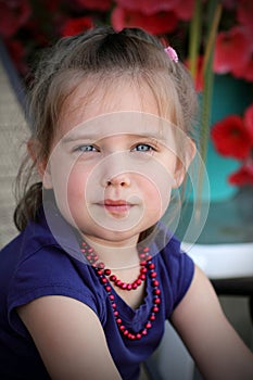 Cute little girl wearing red beads.