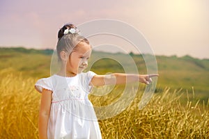 Cute little girl in the white dress in a field