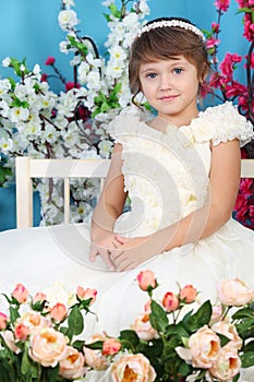 Cute little girl in white dress sits on bench photo