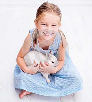 Cute little girl a white rabbit