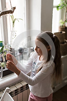 cute little girl in a white t-shirt with braids holding a test tube in her hands