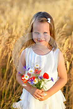 Cute little girl with wild flowers red poppy bouquet