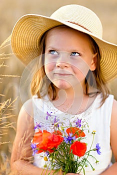 Cute little girl with wild flowers red poppy bouquet