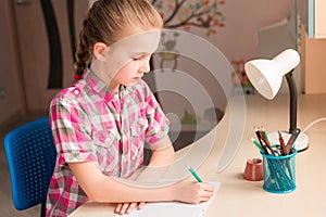 Cute little girl writing her homework