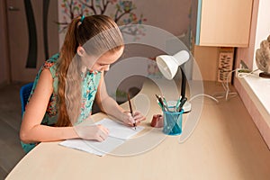 Cute little girl writing her homework