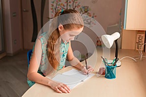 Cute little girl writing her homework