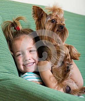 Cute little girl with yorkshire terrier indoor