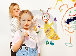 Cute little girls with brushes drawing funny bugs