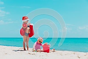 Cute little girls celebrating christmas on tropical beach