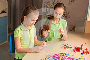 Cute little girls creating toys with chenille sticks photo