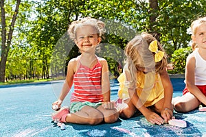 Cute little girls draw with chalk