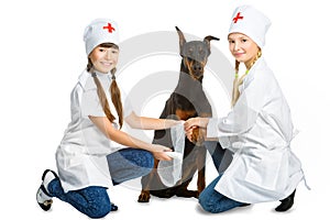 Cute little girls dressed like doctor treated dog