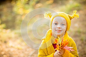 Cute little girls with big bue eyes playing on beautiful autumn day. Happy children having fun in autumn park. The girl