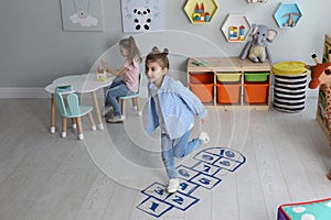 Cute little girls playing hopscotch