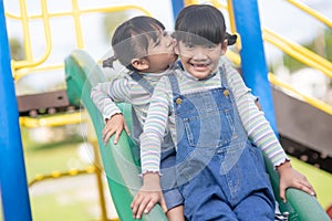 Cute little girls siblings having fun on playground outdoors on a sunny summer day. active sport leisure for kids