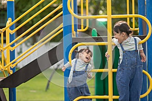 Cute little girls siblings having fun on playground outdoors on a sunny summer day. active sport leisure for kids