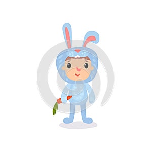 Cute little kid in blue bunny costume standing with carrot in hand. Cartoon child character dressed in animal jumpsuit