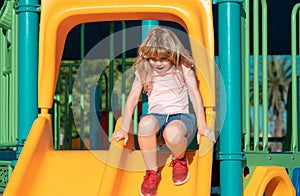 Cute little kid boy funny while playing on the playground. Summer, childhood, leisure and children concept.