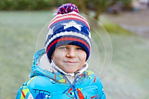 Cute little kid boy in winter clothes outdoors