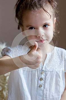 Cute Little kid girl holds thumb up