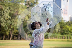 Cute little kid girl playing outdoors in the garden, Child girl with umbrella playing rain in the park